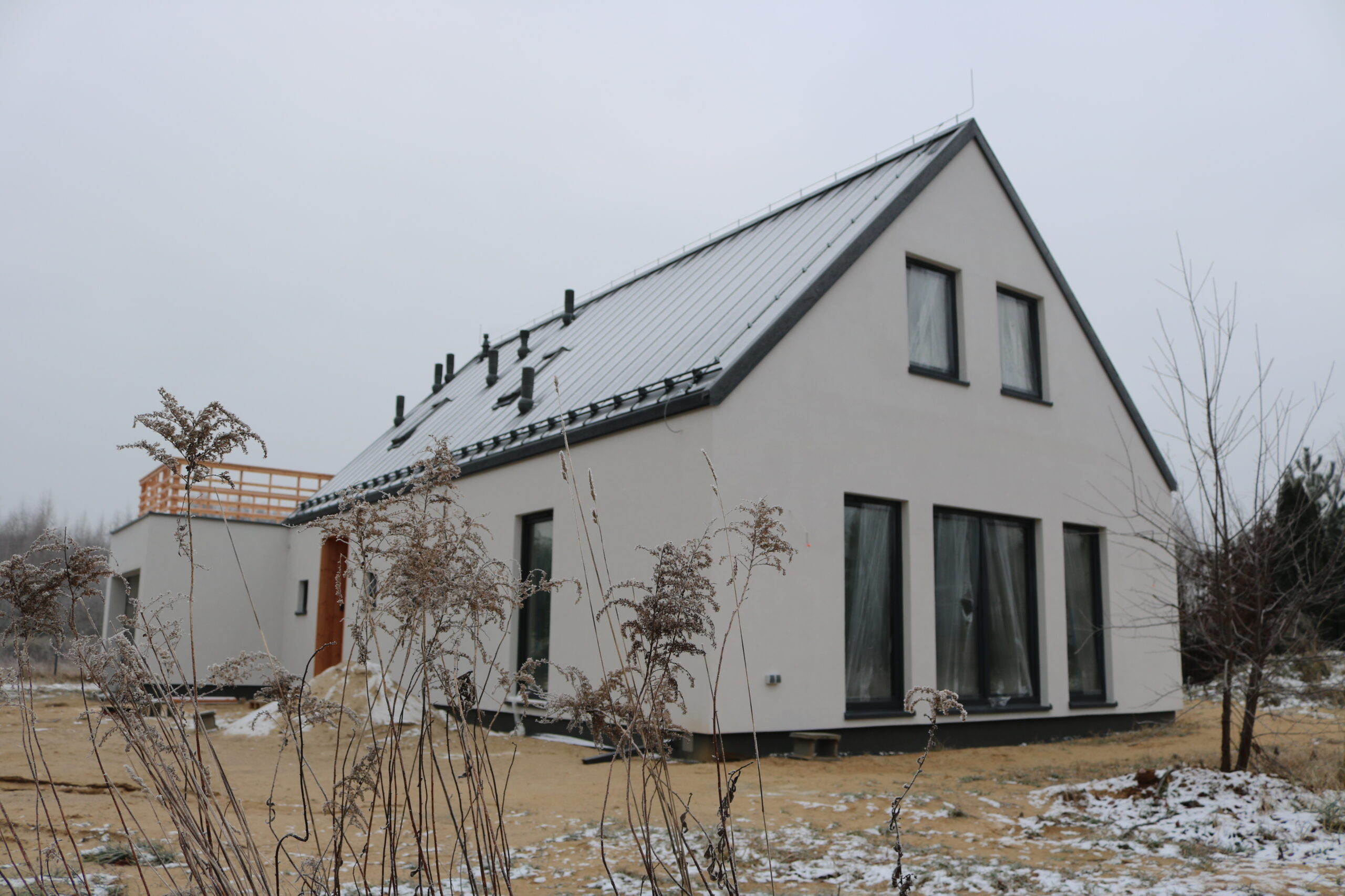 Płaski dach garażu wykorzystany jako taras na piętrze domu Simple House