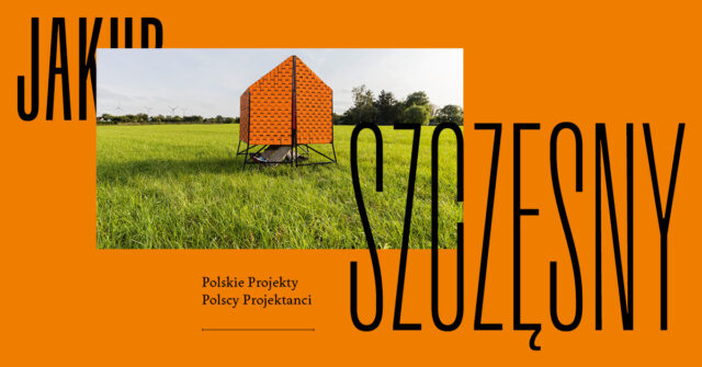 Pomarańczowy baner z projektem Kuby Szczęsnego zaprasza na wystawę architekta